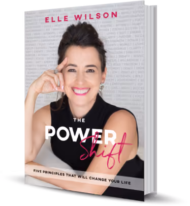The cover of Elle Wilson’s book The Power Shift, subtitled Five Principles That Will Change Your Life, showing her seated and smiling in front of a pale wall printed with repeated words: freedom, strength, clarity, purpose, intimacy, power