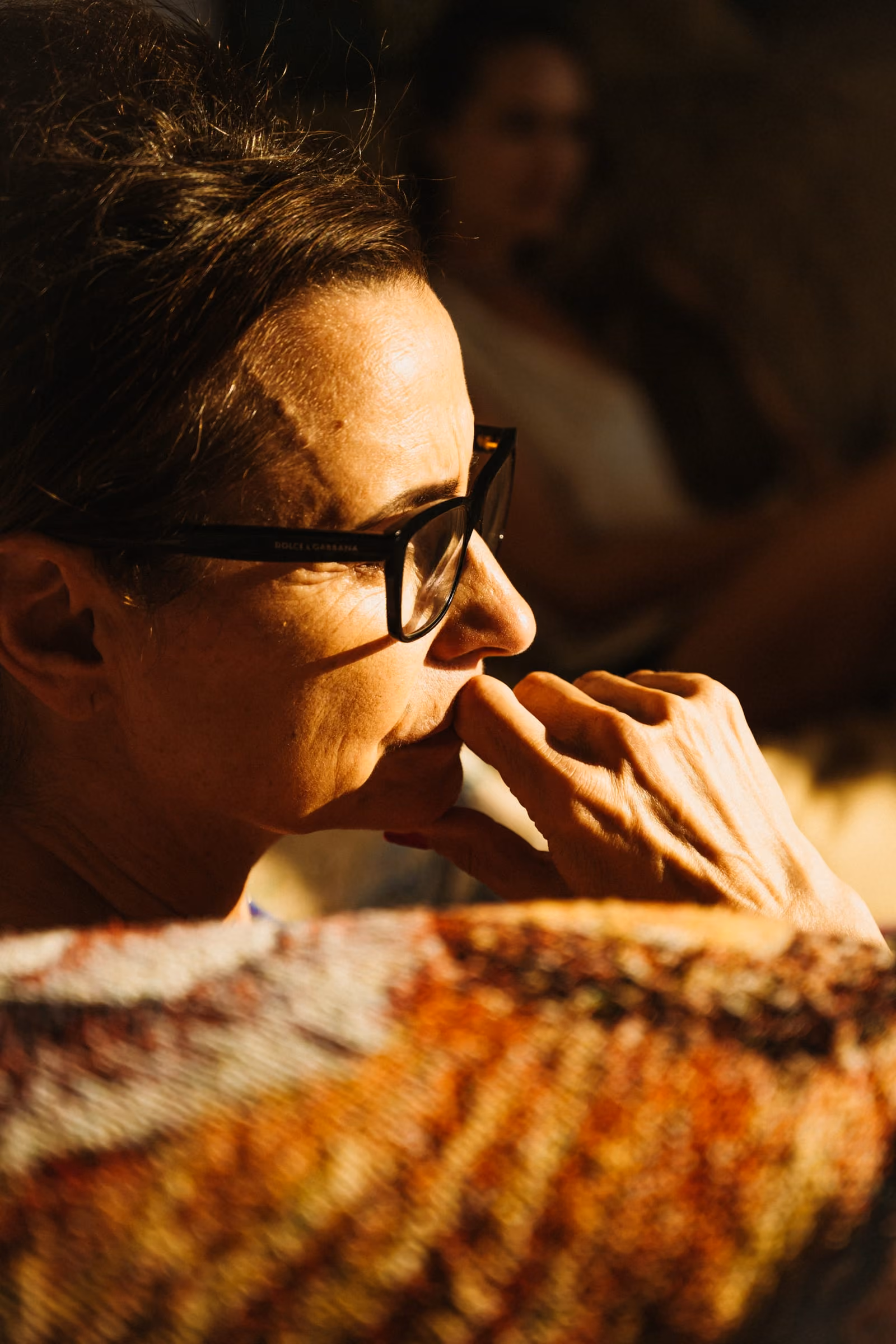 Elle Wilson in profile in warm afternoon light, one hand resting at her mouth
